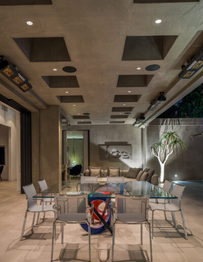 Modern interior dining space with a geometric ceiling design, recessed lighting, and contemporary furnishings.