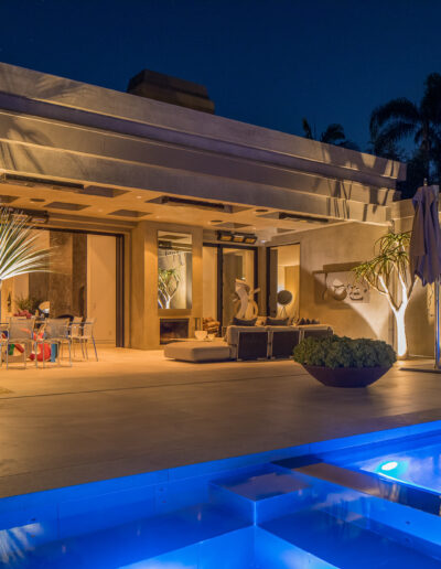 Luxury home exterior with poolside lighting at dusk.