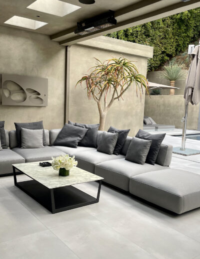 Modern outdoor living area with an l-shaped sectional sofa and a central coffee table.