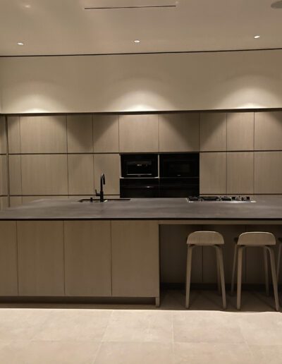 Modern kitchen with a central island, bar stools, and built-in appliances.